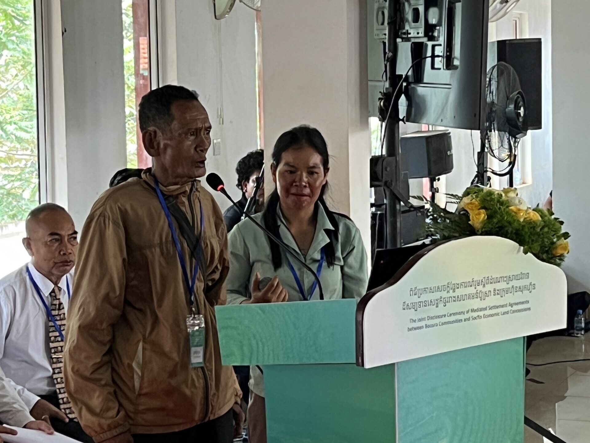 Mr. Brong Teuch, an elder from Bour Sra Village stands at the podium and addresses the crowd at the land title ceremony.